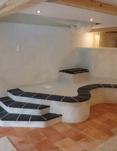 Poêle de masse départ d'escalier et grand banc courbe